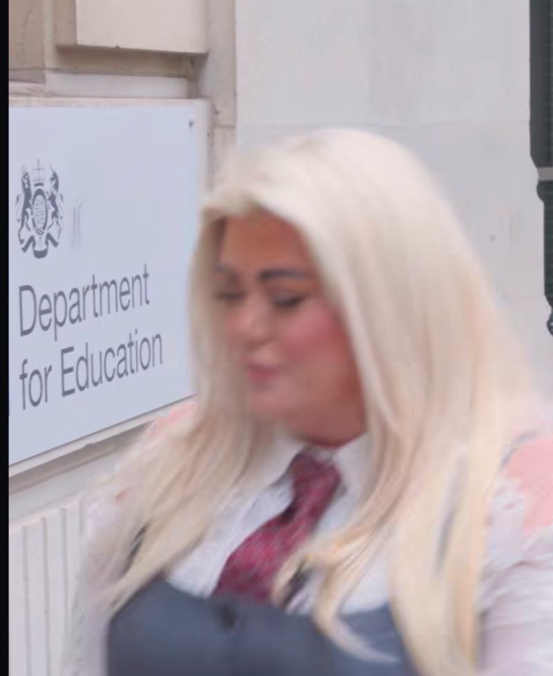 Person walking past the Department for Education sign